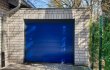 Blauwe garagedeur in de schaduw